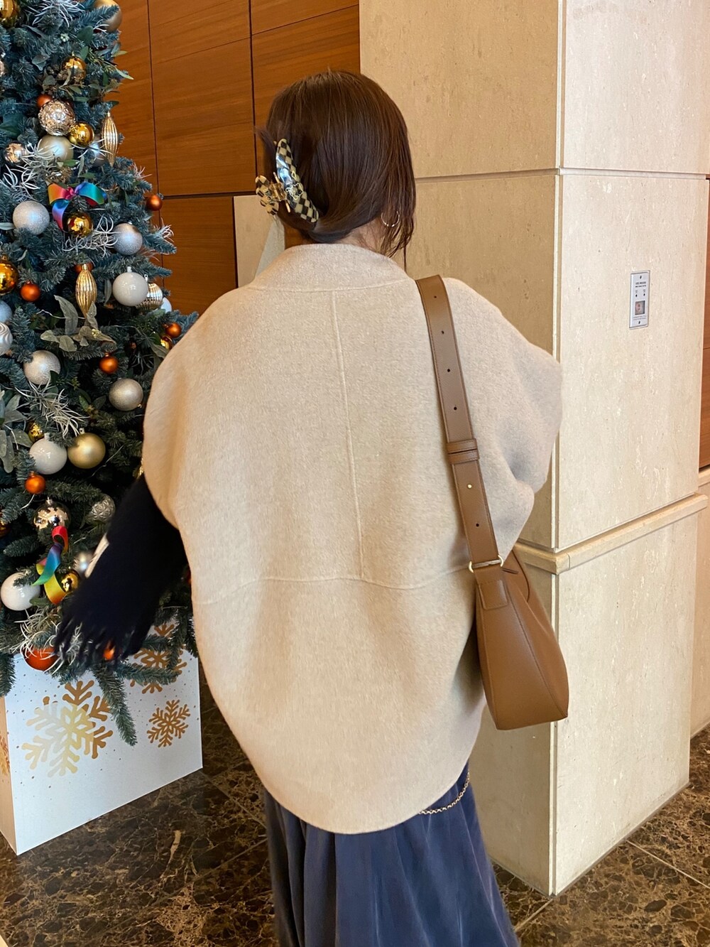 イエロー系のその他アウター、ホワイト系のニット/セーター、ホワイト系のスカートを着用したレディースの冬コーディネートの7枚目の写真
