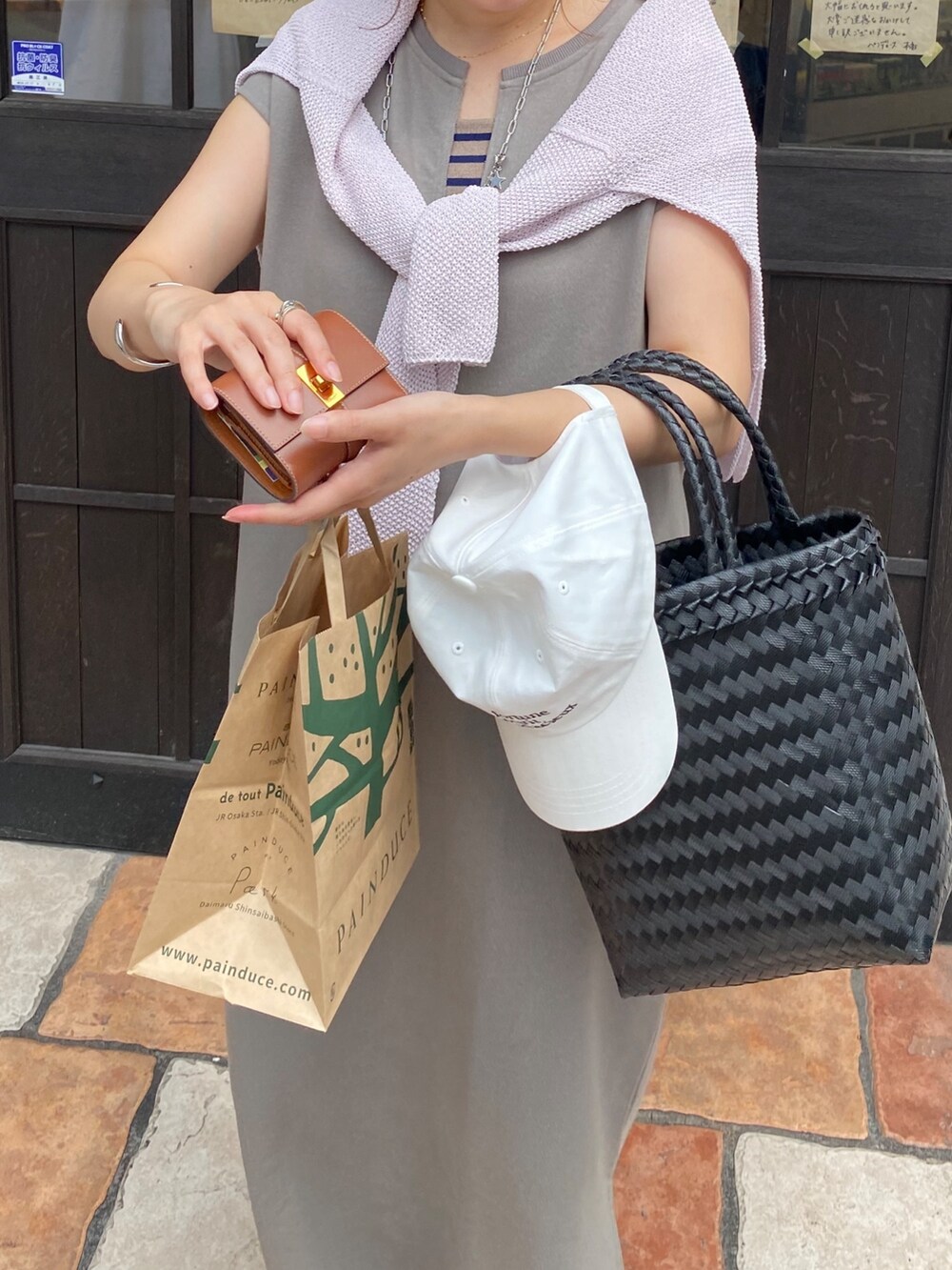 ホワイト系のワンピース、ブラック系のかごバッグ、ブラック系のニット/セーターを着用したレディースの春コーディネートの4枚目の写真