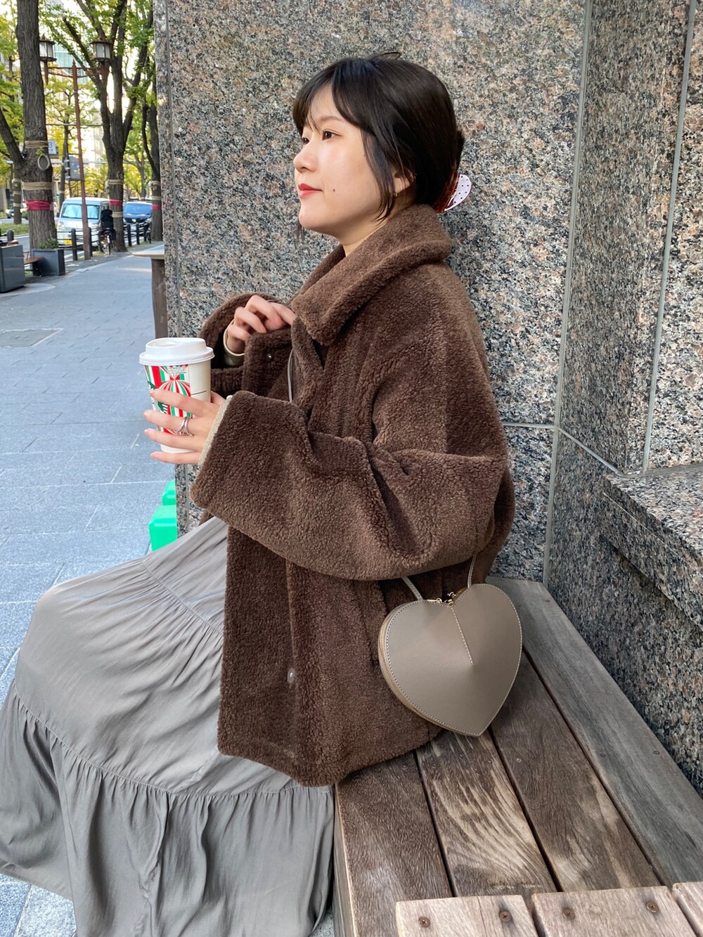 ブラウン系のその他アウター、ブラウン系のワンピース、ゴールド系のTシャツ/カットソーを着用したレディースの冬コーディネートの4枚目の写真