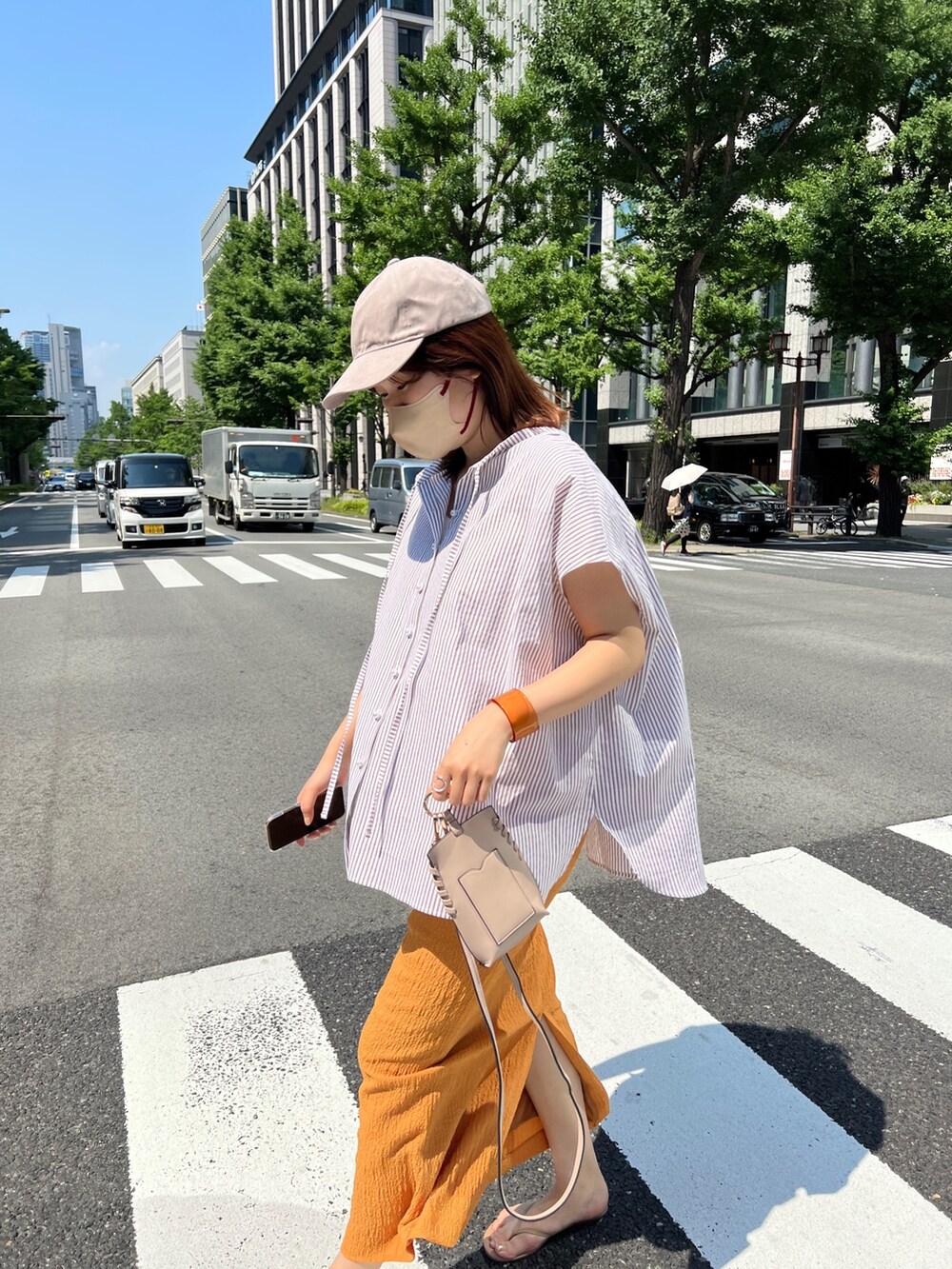 ベージュ系のシャツ/ブラウス、オレンジ系のスカート、ベージュ系のその他シューズを着用したレディースの夏コーディネートの3枚目の写真