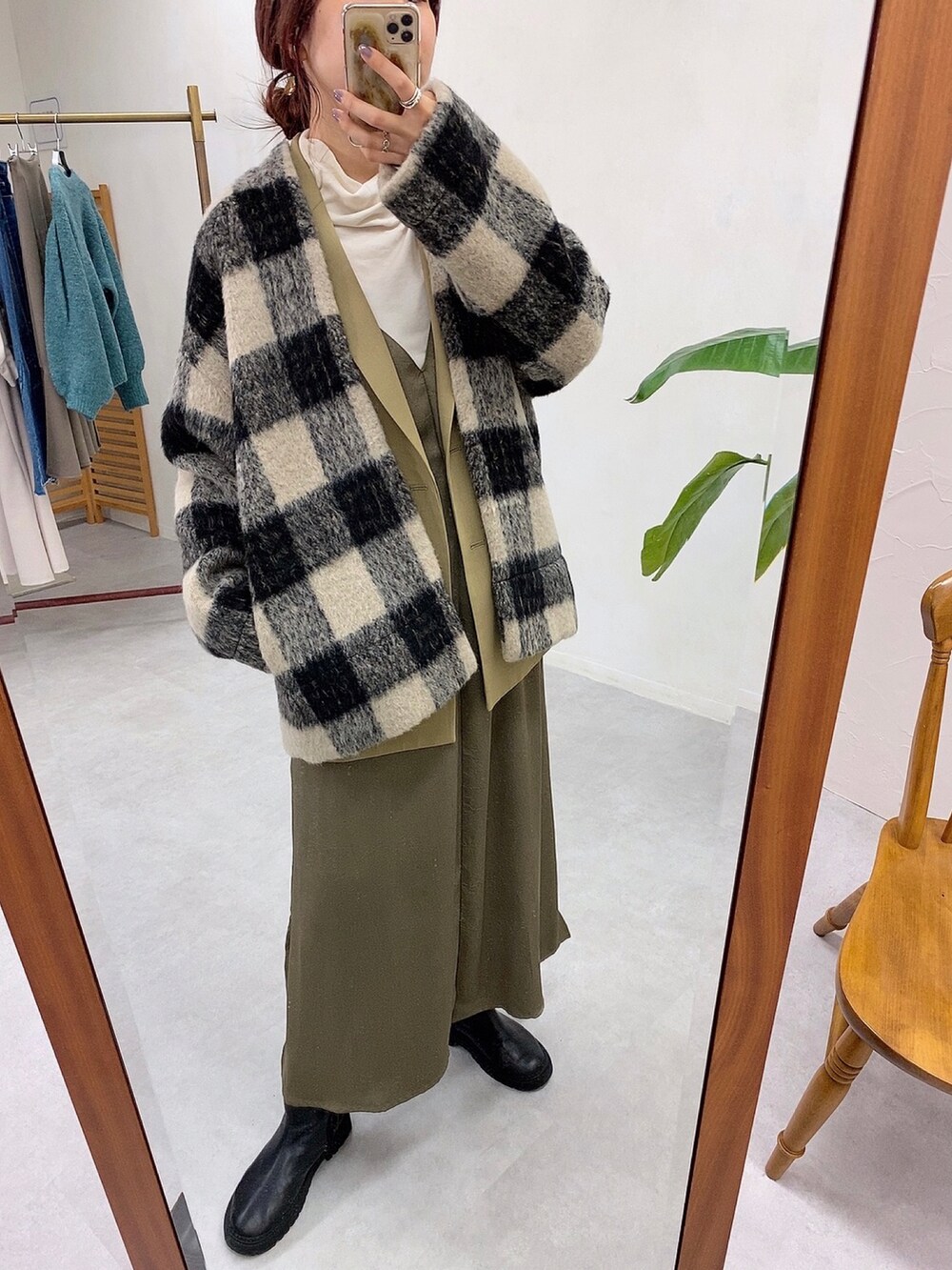 ブラック系のその他アウター、グリーン系のワンピース、ブラック系のブーツを着用したレディースの冬コーディネートの2枚目の写真