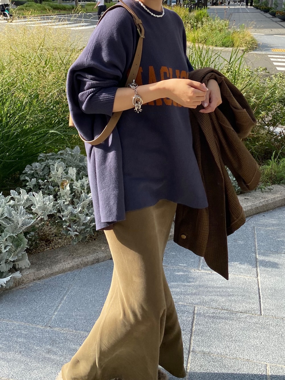 ブルー系のニット/セーター、グリーン系のスカート、ブラウン系のテーラードジャケットを着用したレディースの秋コーディネートの2枚目の写真