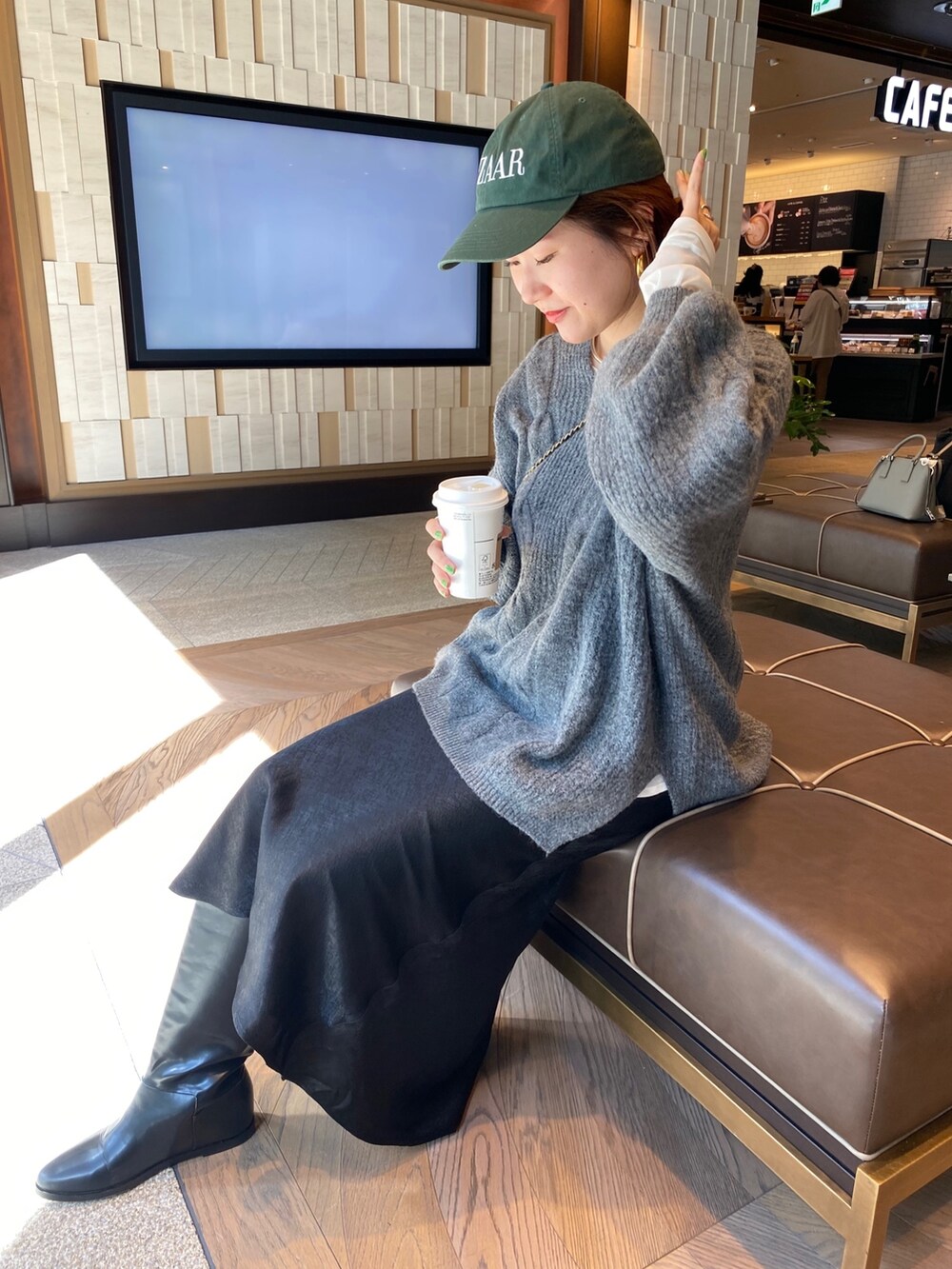 グレー系のニット/セーター、ブラック系のスカートを着用したレディースの秋コーディネートの8枚目の写真