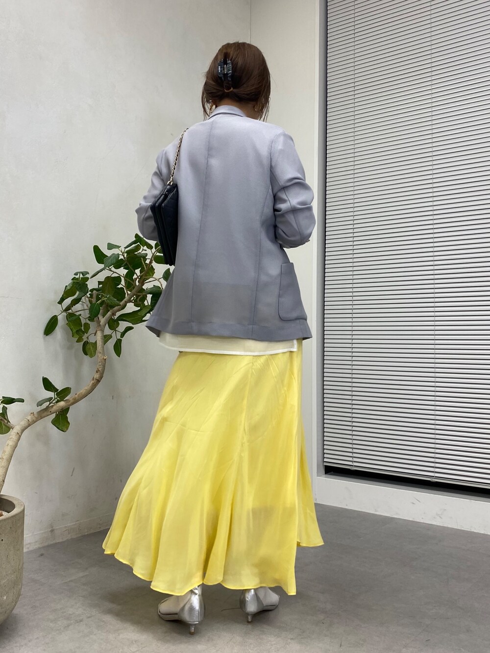 イエロー系のスカート、ホワイト系のシャツ/ブラウス、ブラック系のショルダーバッグを着用したレディースの冬コーディネートの9枚目の写真