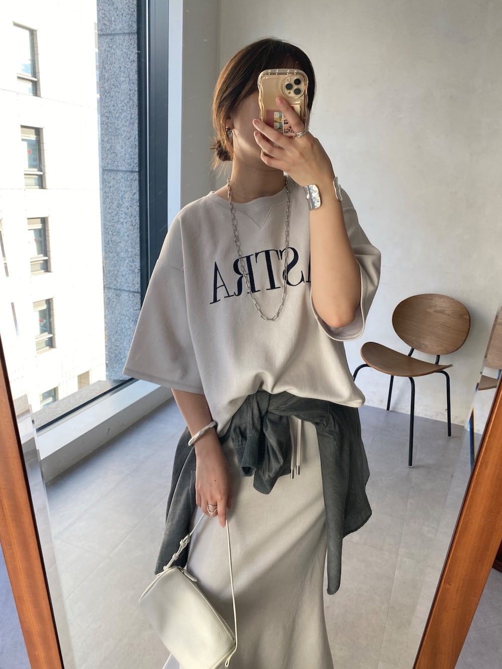 ベージュ系のTシャツ/カットソー、ベージュ系のスカート、ブラック系のシャツ/ブラウスを着用したレディースの冬コーディネートの3枚目の写真