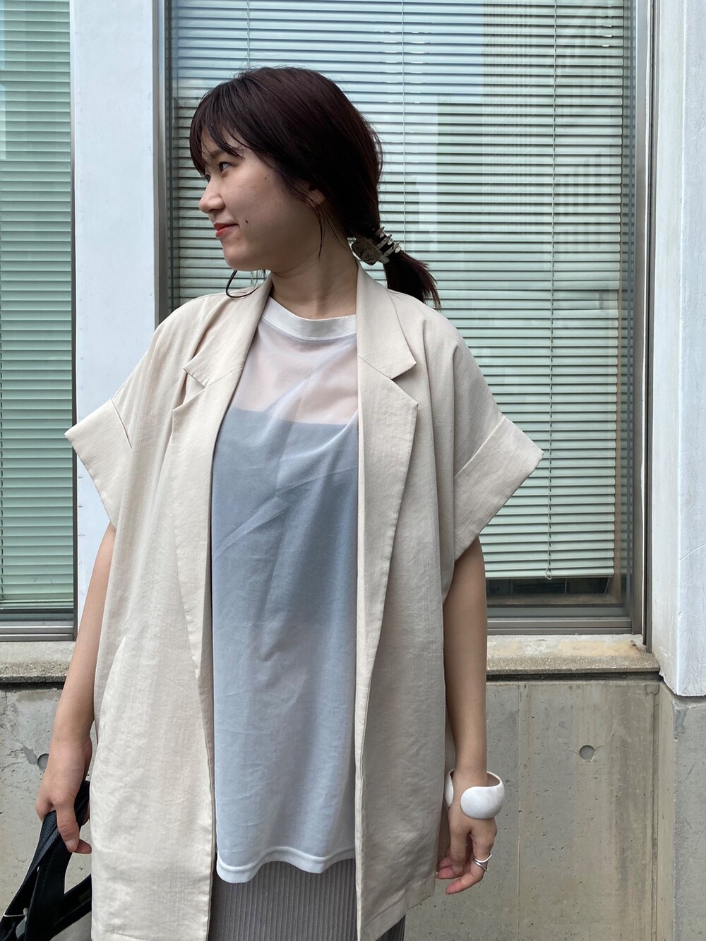 グレー系のワンピース、ベージュ系のテーラードジャケットを着用したレディースの夏コーディネートの5枚目の写真