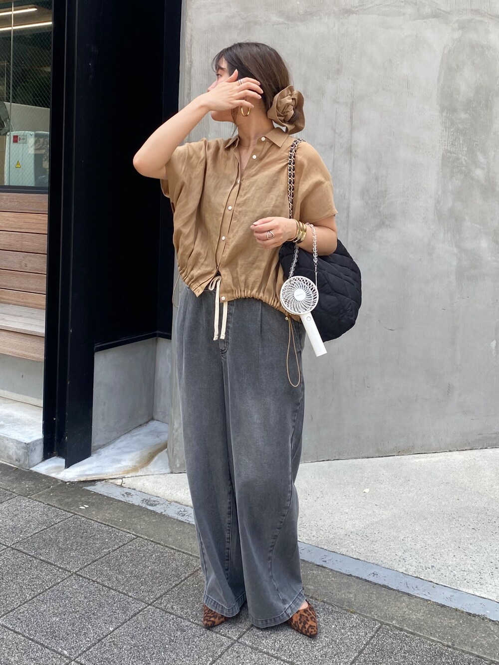 ベージュ系のシャツ/ブラウス、ブラック系のデニムパンツ、ブラウン系のシュシュを着用したレディースの夏コーディネートの4枚目の写真