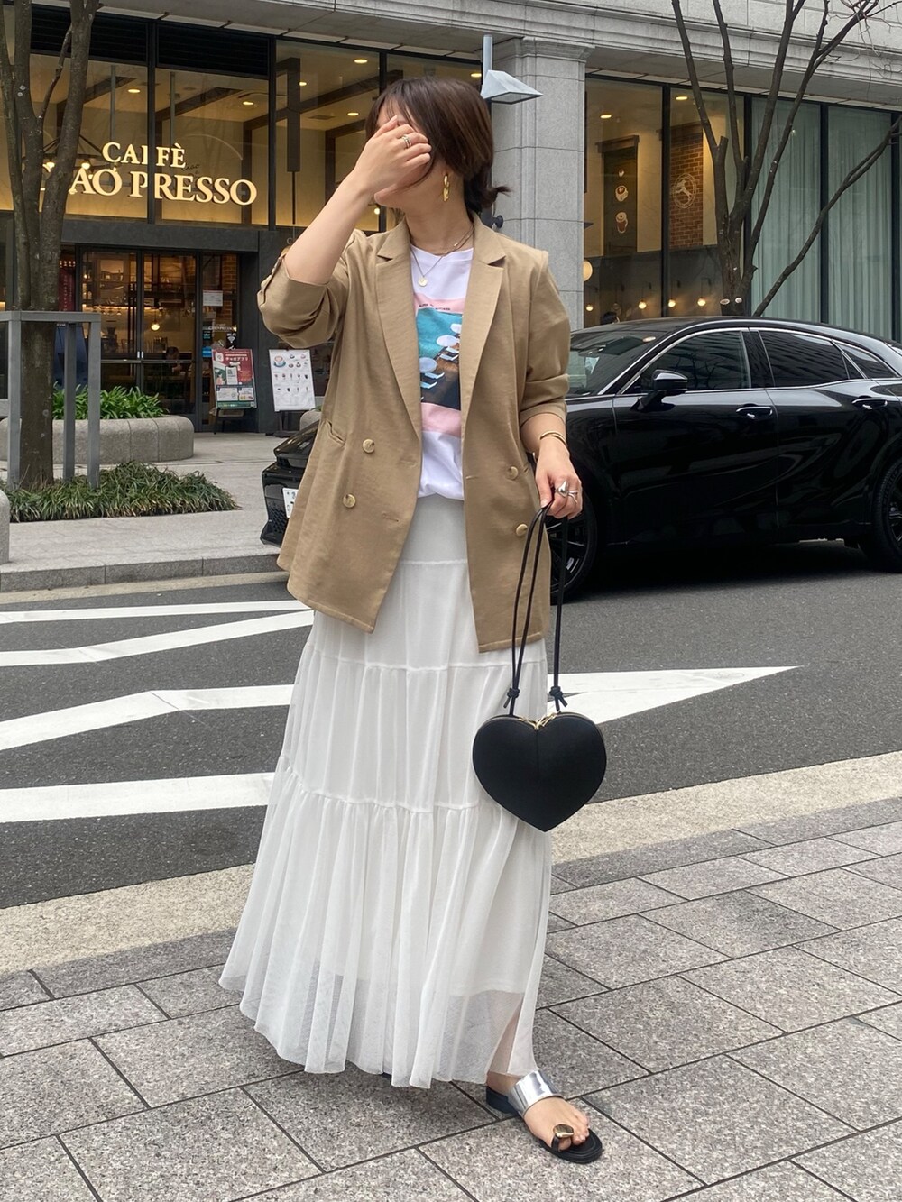 イエロー系のテーラードジャケット、ホワイト系のTシャツ/カットソー、ホワイト系のスカートを着用したレディースの春コーディネートの6枚目の写真