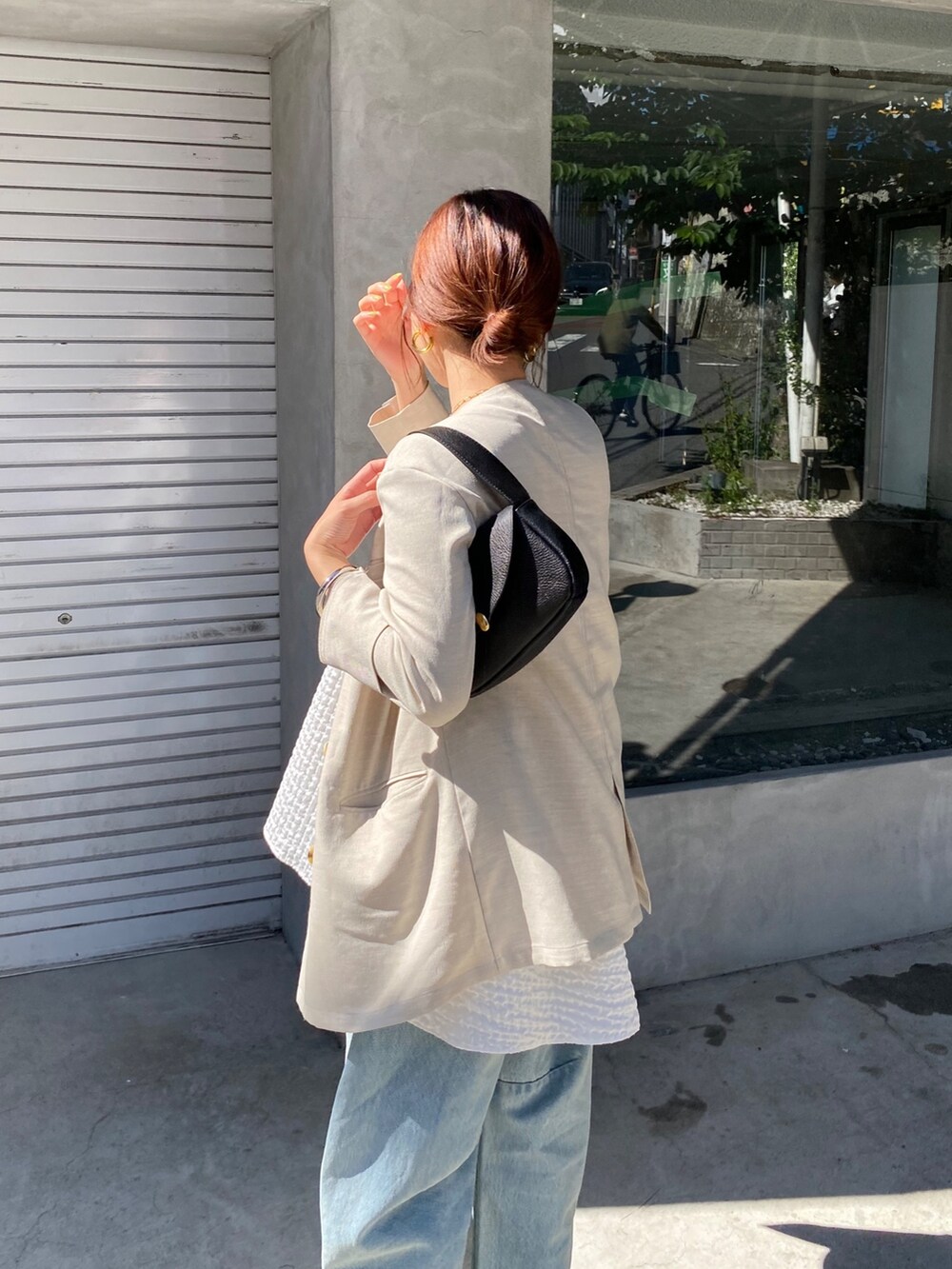 ホワイト系のキャミソール、ブルー系のデニムパンツ、ブラック系のショルダーバッグを着用したレディースの夏コーディネートの5枚目の写真