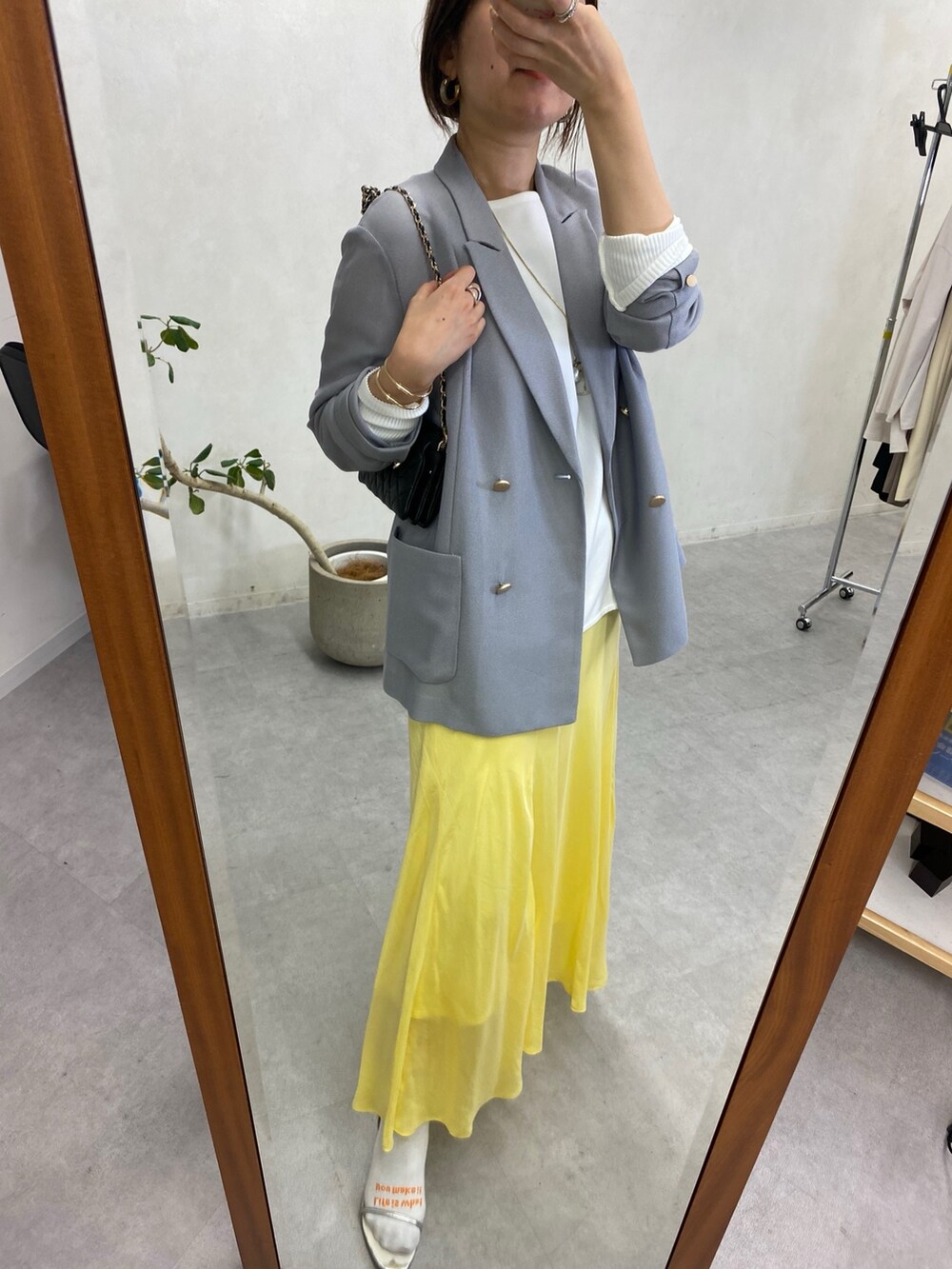 イエロー系のスカート、ホワイト系のシャツ/ブラウス、ブラック系のショルダーバッグを着用したレディースの冬コーディネートの7枚目の写真