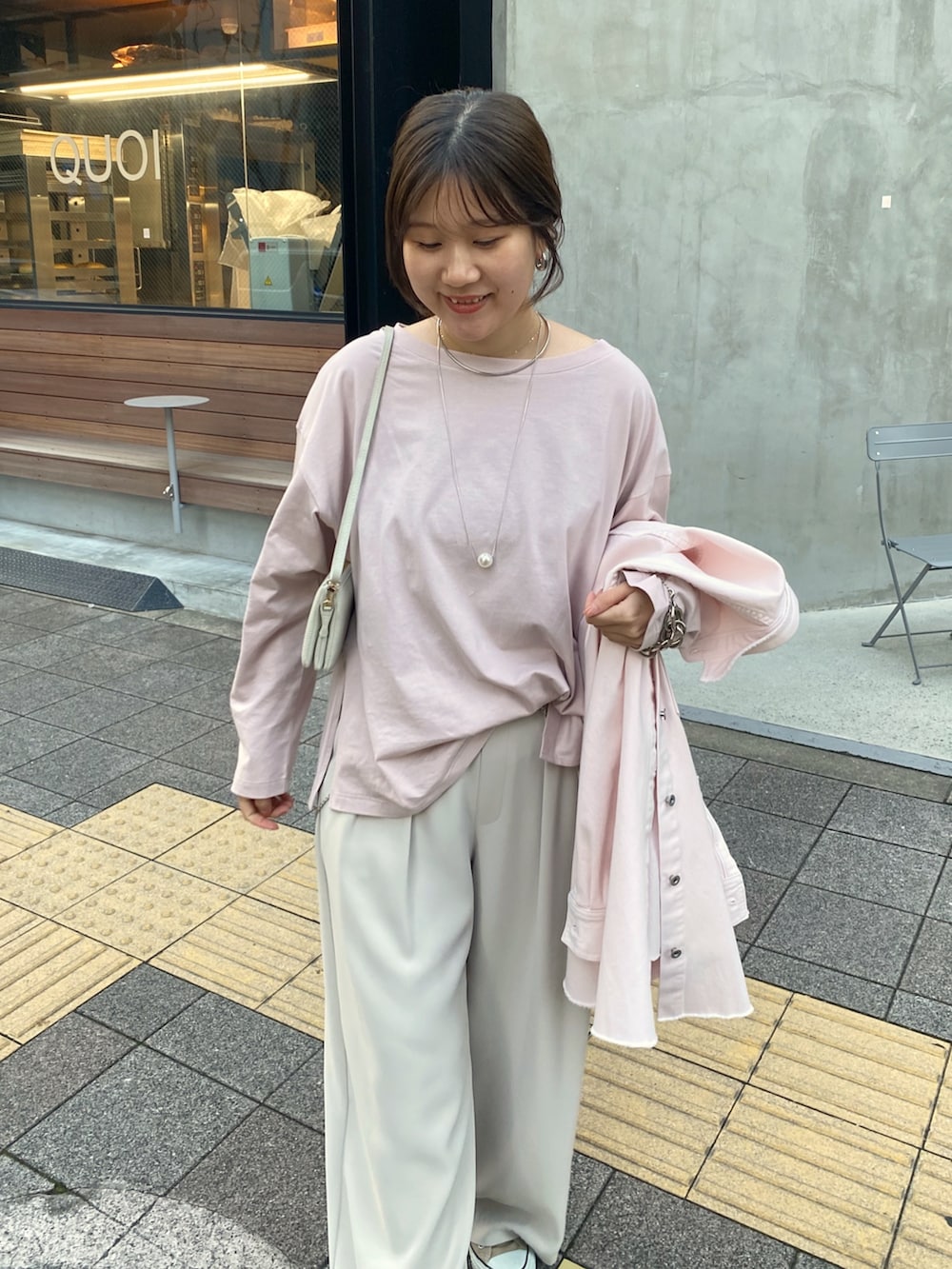 ピンク系のシャツ/ブラウス、ピンク系のTシャツ/カットソー、グレー系のスラックスを着用したレディースの冬コーディネートの6枚目の写真