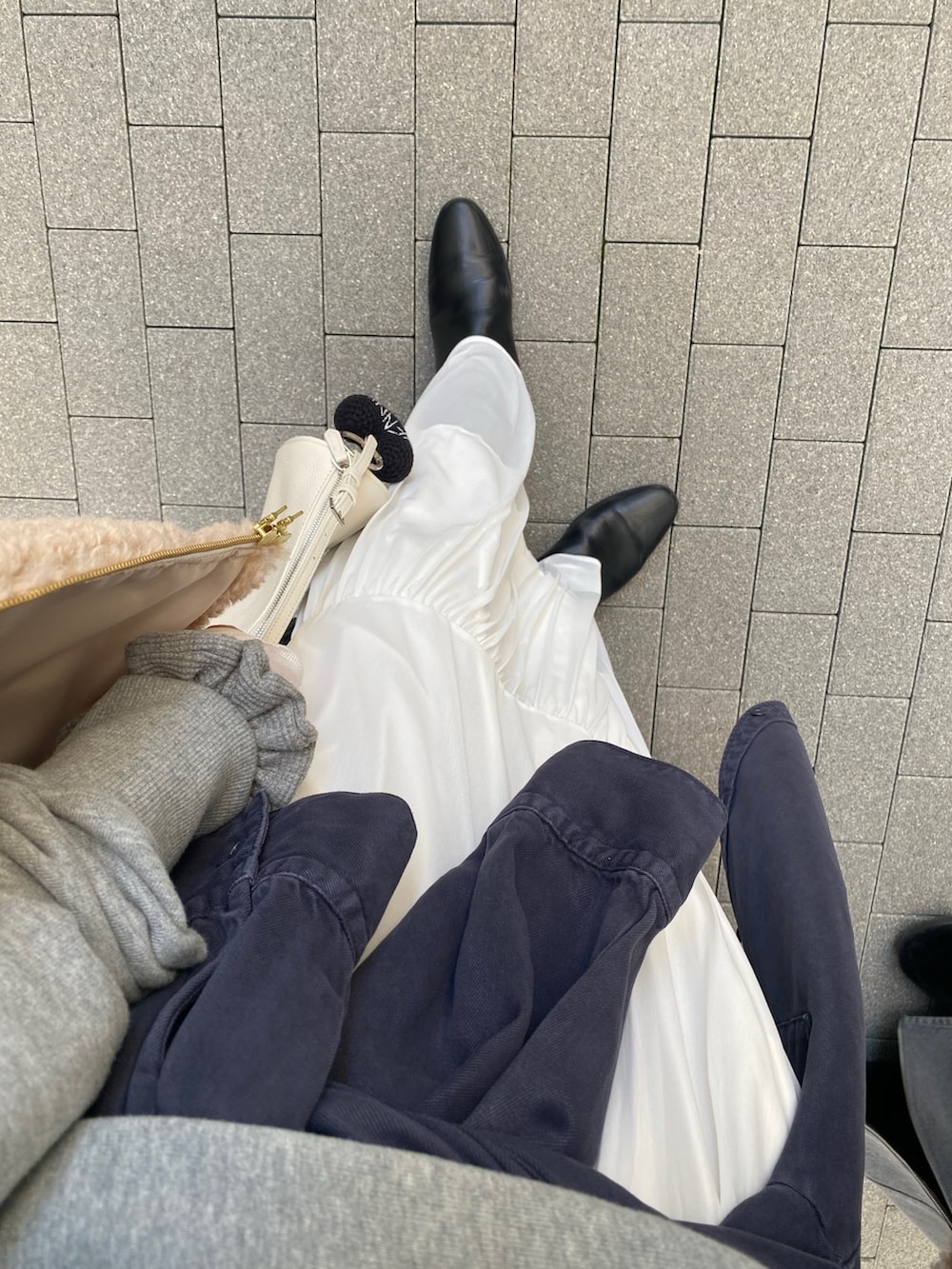 グレー系のスウェット、ブルー系のシャツ/ブラウス、ホワイト系のスカートを着用したレディースの冬コーディネートの3枚目の写真