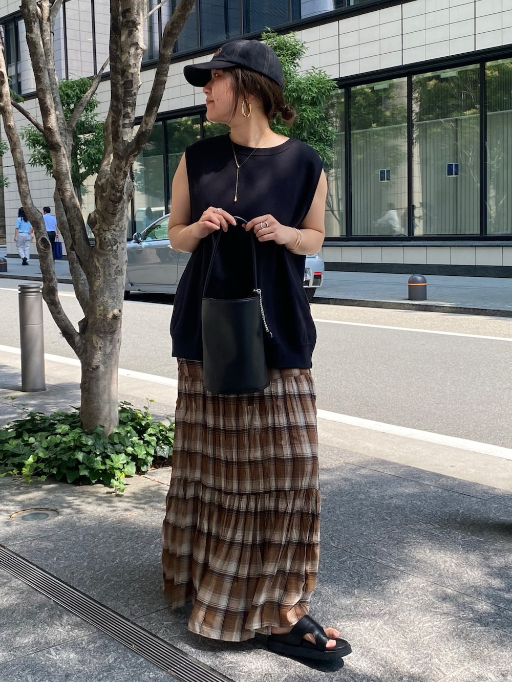ブラック系のTシャツ/カットソー、ブラウン系のスカート、ブラック系のショルダーバッグを着用したレディースの夏コーディネートの7枚目の写真