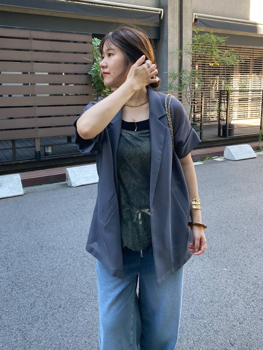 グレー系のテーラードジャケット、グリーン系のシャツ/ブラウス、ブルー系のその他パンツを着用したレディースの秋コーディネートの4枚目の写真