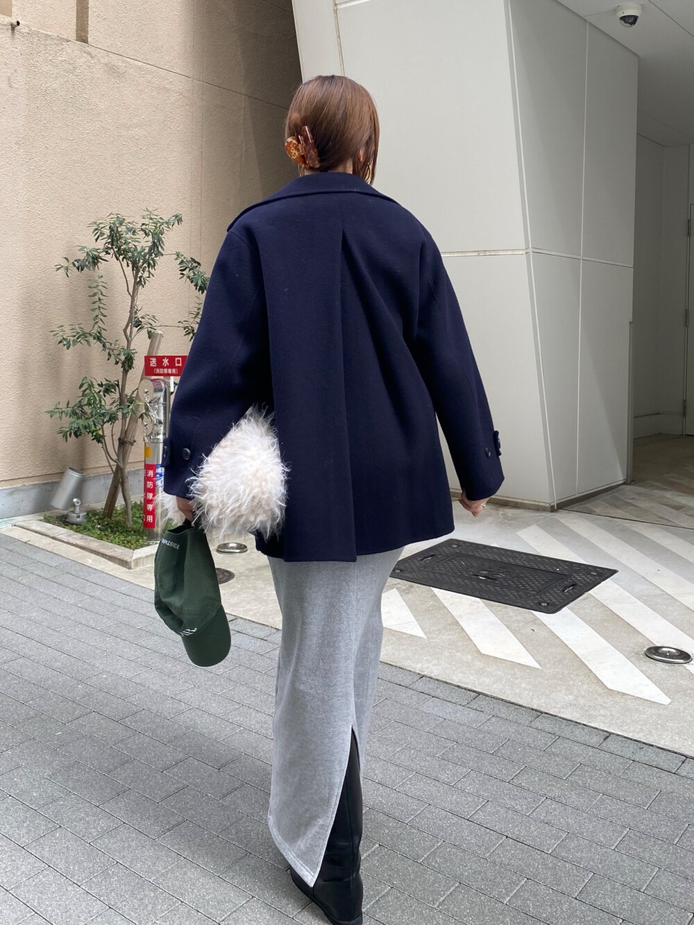 シルバー系のスウェット、シルバー系のスカート、ブラック系のブーツを着用したレディースの秋コーディネートの9枚目の写真