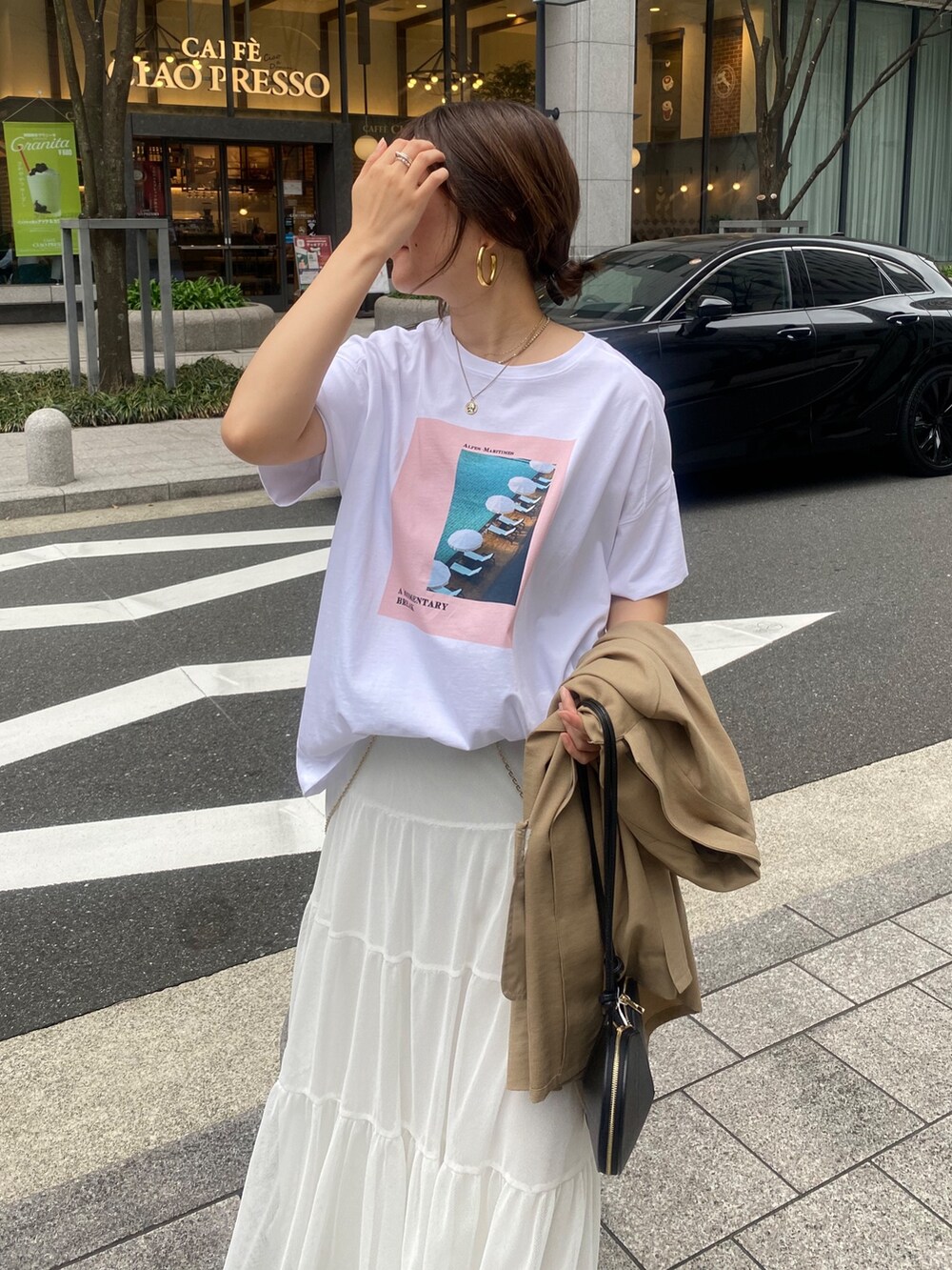イエロー系のテーラードジャケット、ホワイト系のTシャツ/カットソー、ホワイト系のスカートを着用したレディースの春コーディネートの2枚目の写真