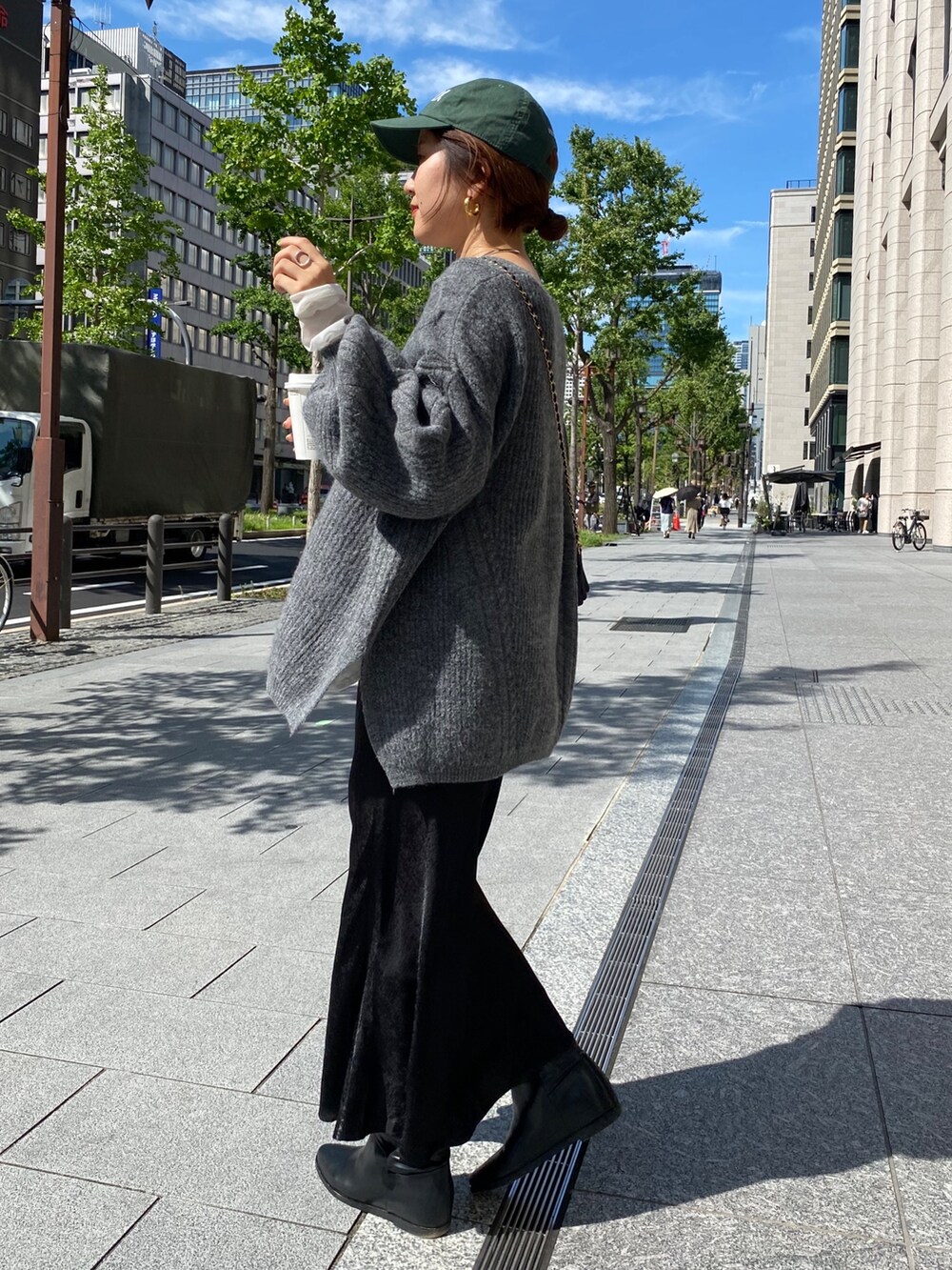 グレー系のニット/セーター、ブラック系のスカートを着用したレディースの秋コーディネートの3枚目の写真