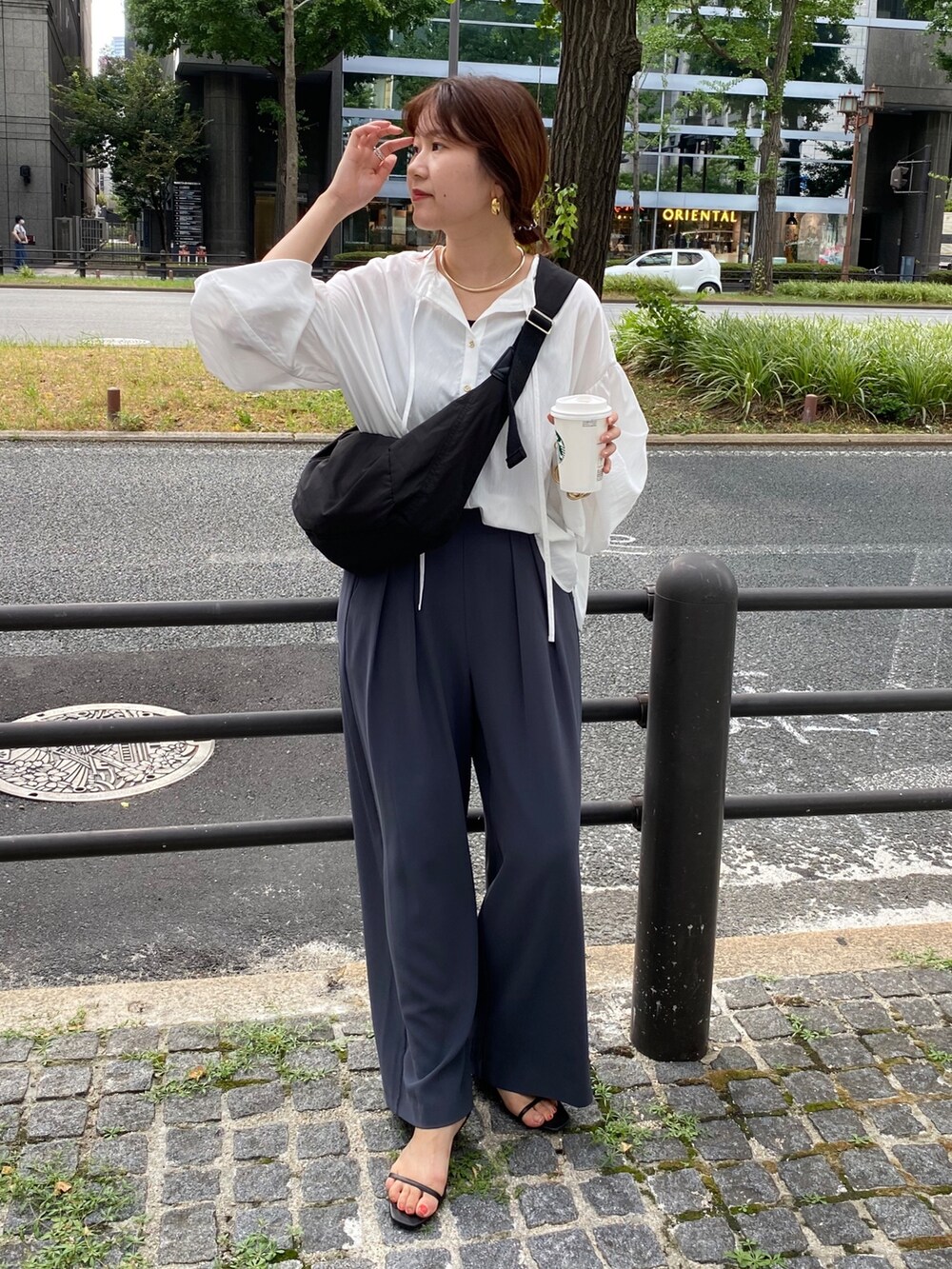 ホワイト系のシャツ/ブラウス、グレー系のスラックス、シルバー系のサンダルを着用したレディースの夏コーディネートの10枚目の写真