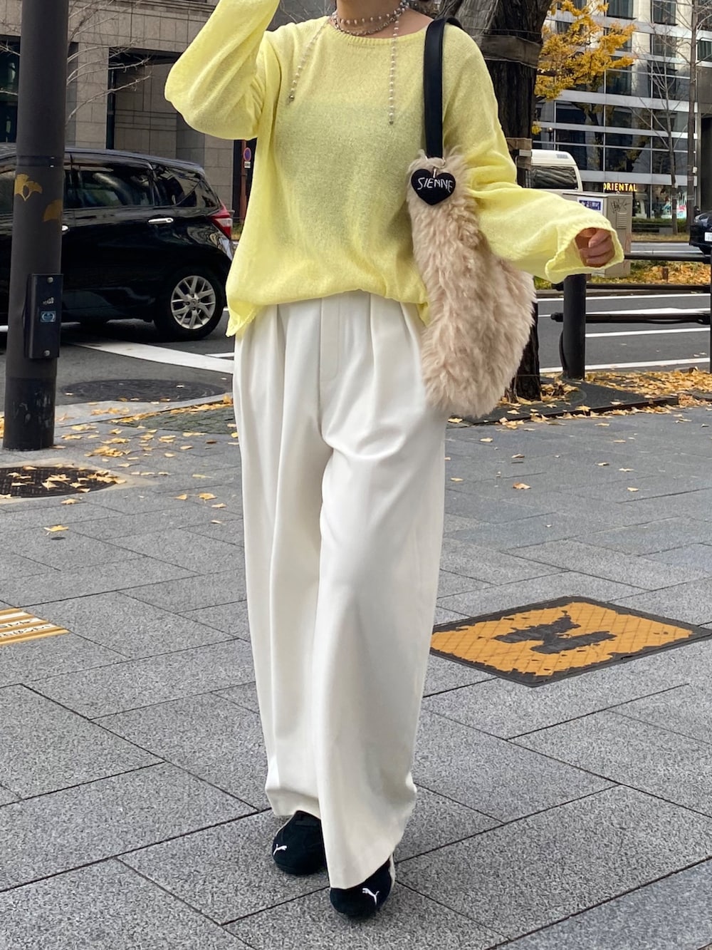 イエロー系のニット/セーター、イエロー系のTシャツ/カットソー、ホワイト系のその他パンツを着用したレディースの冬コーディネートの5枚目の写真