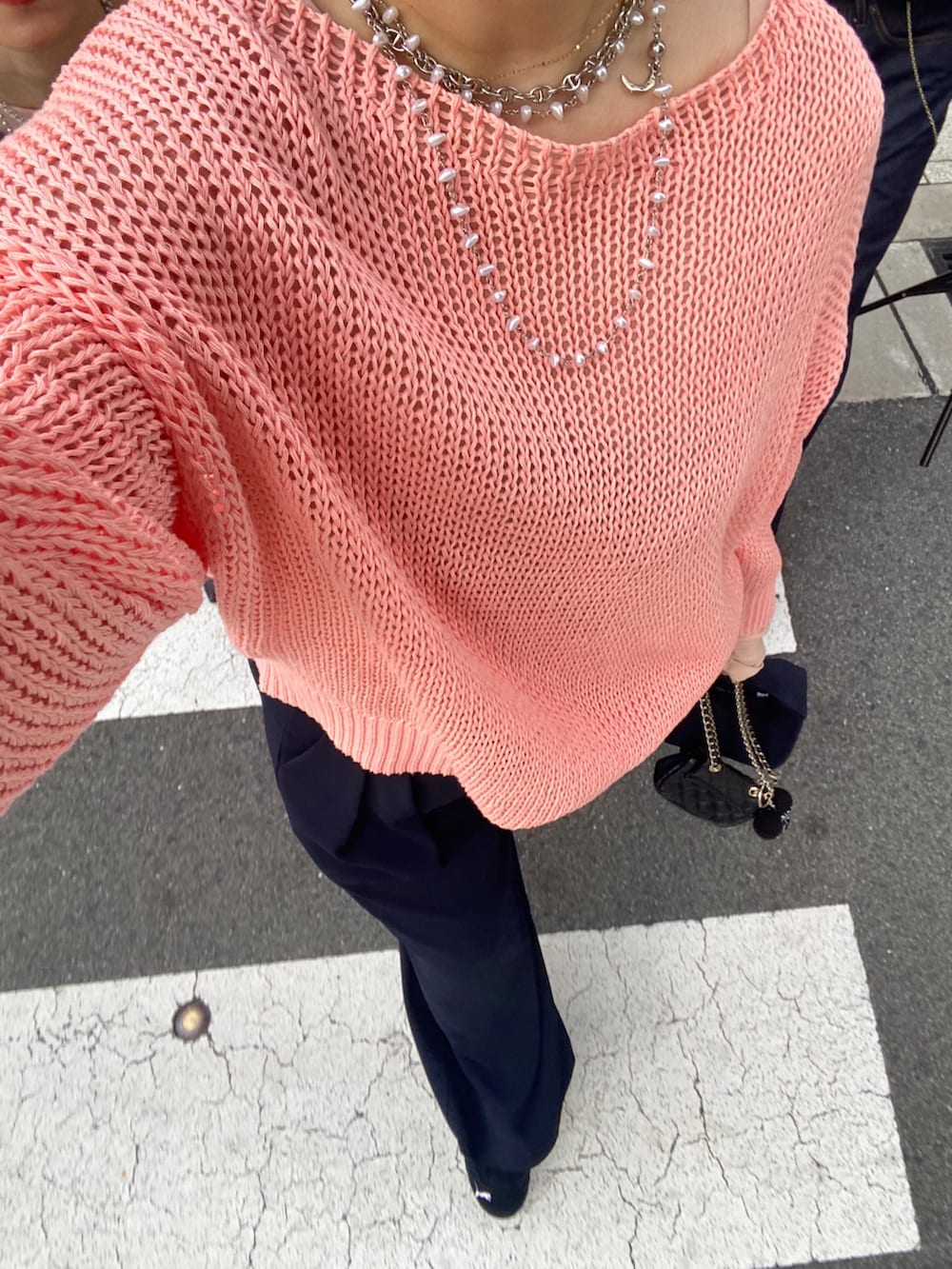 ピンク系のニット/セーター、ピンク系のTシャツ/カットソー、ブルー系のスラックスを着用したレディースの冬コーディネートの2枚目の写真