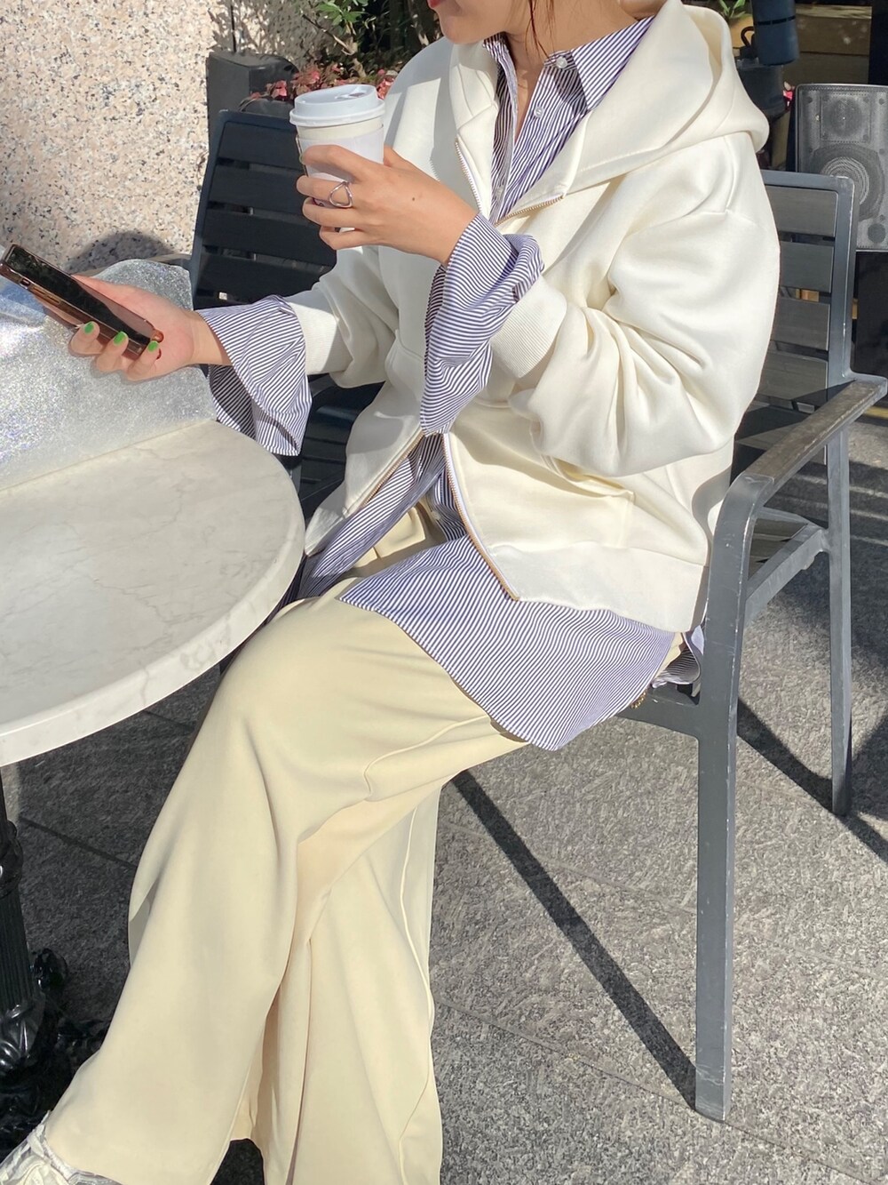 ホワイト系のパーカー、ブラック系のシャツ/ブラウス、イエロー系のスラックスを着用したレディースの冬コーディネートの9枚目の写真