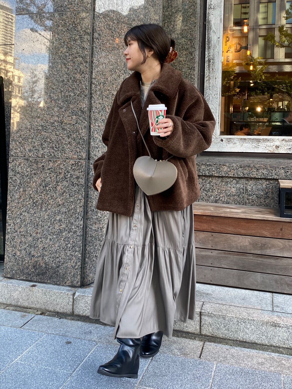 ブラウン系のその他アウター、ブラウン系のワンピース、ゴールド系のTシャツ/カットソーを着用したレディースの冬コーディネートの3枚目の写真