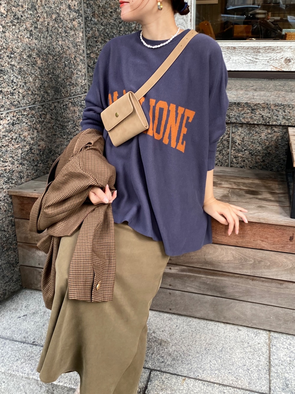 ブルー系のニット/セーター、グリーン系のスカート、ブラウン系のテーラードジャケットを着用したレディースの秋コーディネートの4枚目の写真