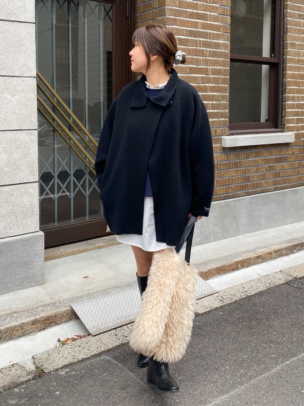 ブラック系のその他アウター、ブルー系のTシャツ/カットソー、ホワイト系のシャツ/ブラウスを着用したレディースの冬コーディネートの6枚目の写真