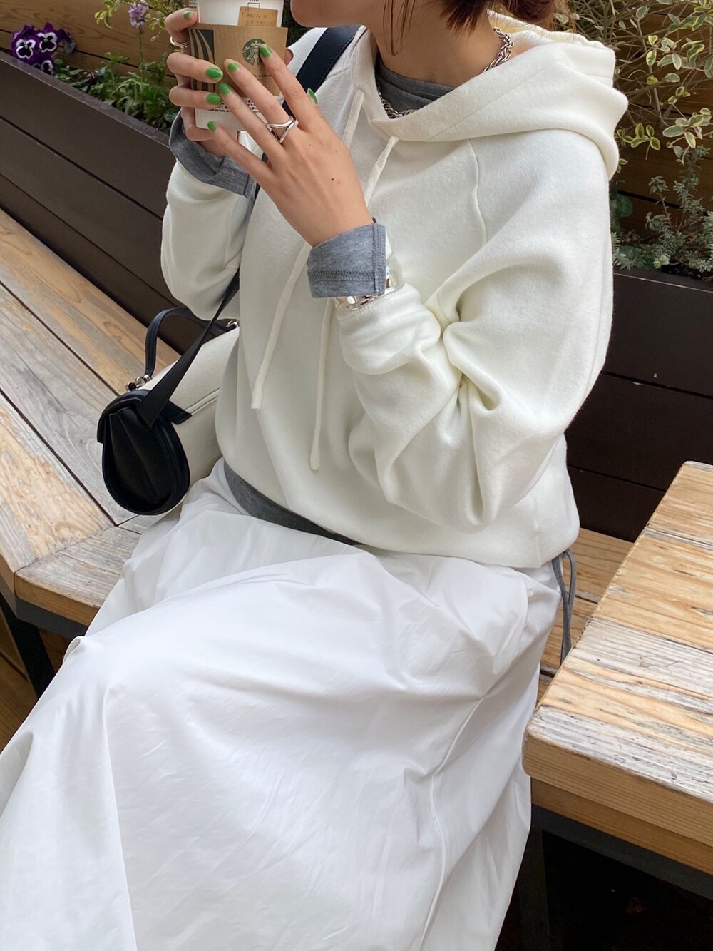 ホワイト系のスカート、ブラウン系のショルダーバッグ、グレー系のTシャツ/カットソーを着用したレディースの春コーディネートの7枚目の写真