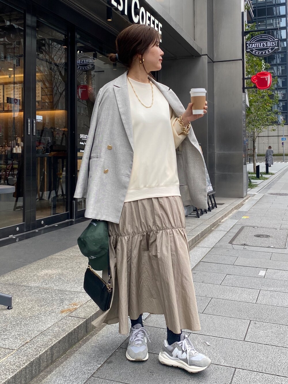 ホワイト系のワンピース、グレー系のテーラードジャケット、ゴールド系のブレスレットを着用したレディースの冬コーディネートの7枚目の写真