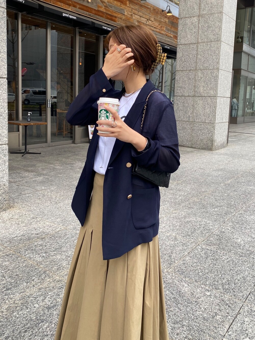 ホワイト系のTシャツ/カットソー、ブルー系のテーラードジャケット、ブラック系のスカートを着用したレディースの春コーディネートの3枚目の写真