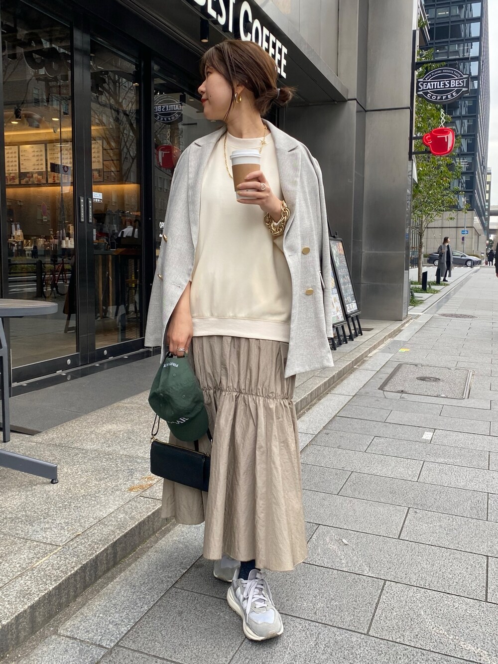 ホワイト系のワンピース、グレー系のテーラードジャケット、ゴールド系のブレスレットを着用したレディースの冬コーディネートの2枚目の写真