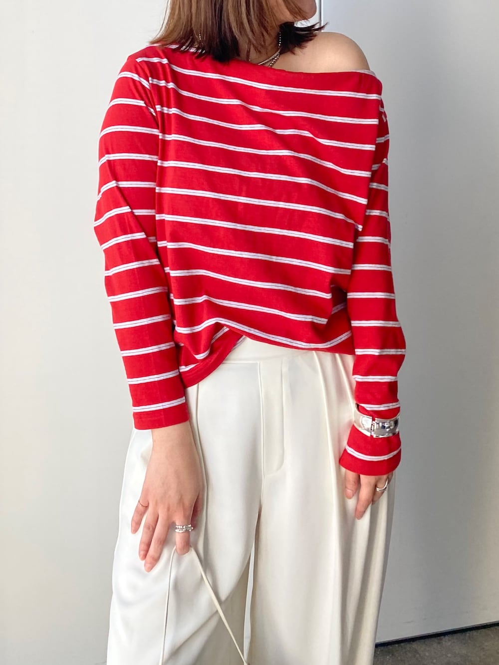 レッド系のTシャツ/カットソー、ホワイト系のスラックスを着用したレディースの春コーディネートの3枚目の写真