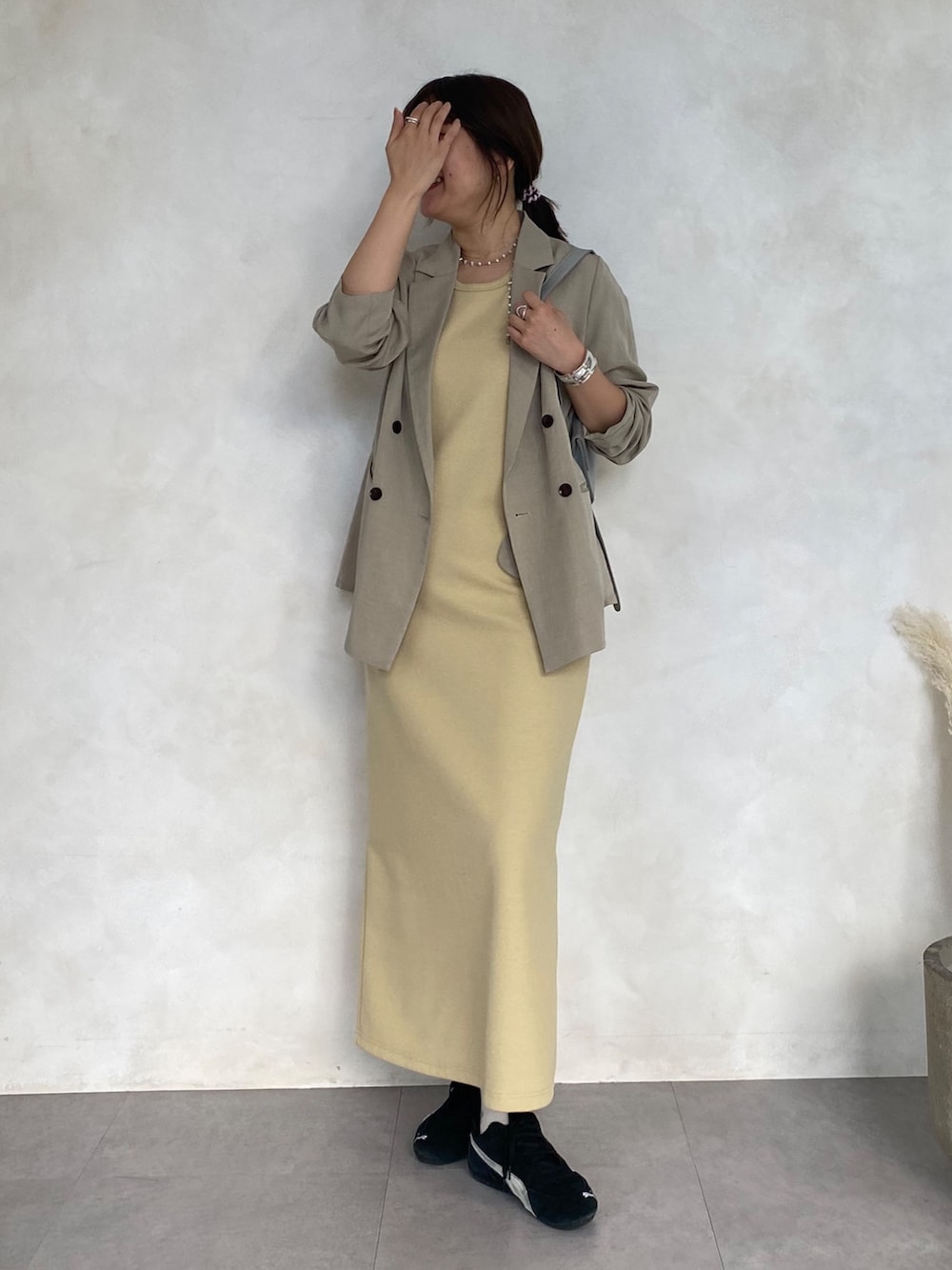 イエロー系のワンピースを着用したレディースの春コーディネートの3枚目の写真