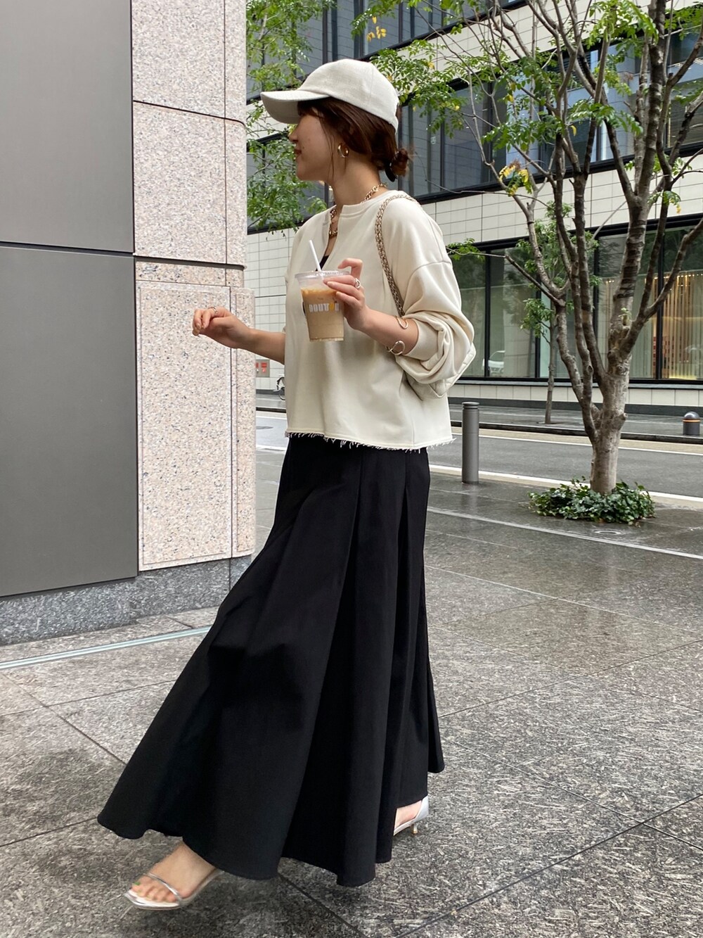 ベージュ系のスウェット、ブラック系のスカート、ホワイト系のショルダーバッグを着用したレディースの冬コーディネートの2枚目の写真