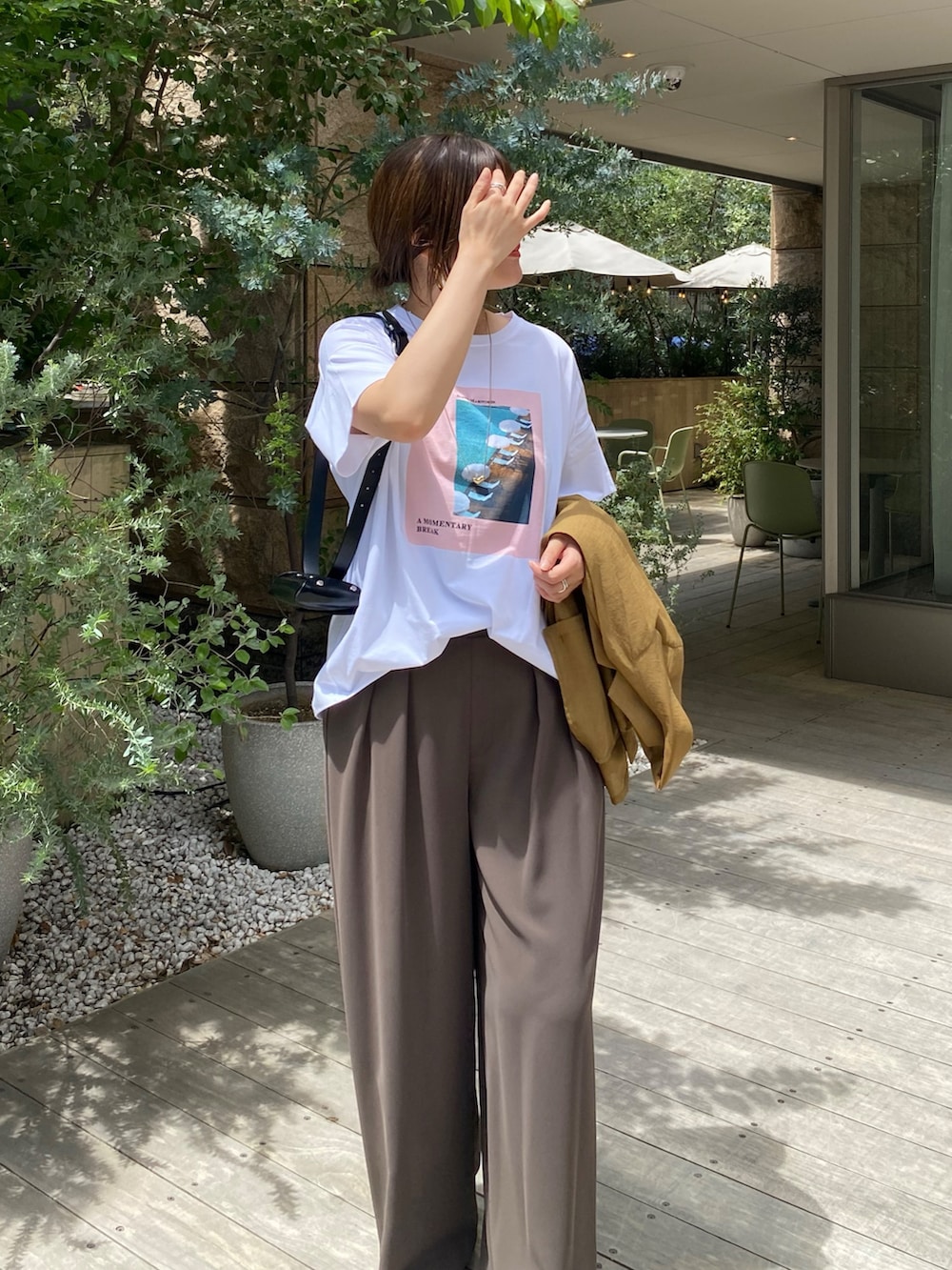 イエロー系のテーラードジャケット、ホワイト系のTシャツ/カットソー、ブラウン系のスラックスを着用したレディースの夏コーディネートの6枚目の写真