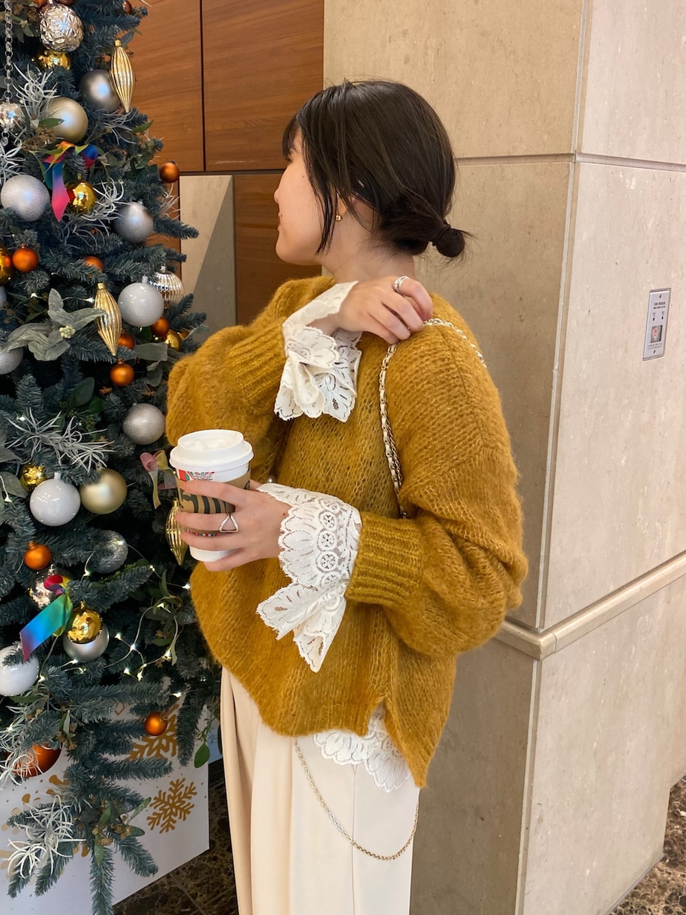 ベージュ系のその他アウター、イエロー系のニット/セーター、ホワイト系のシャツ/ブラウスを着用したレディースの冬コーディネートの6枚目の写真