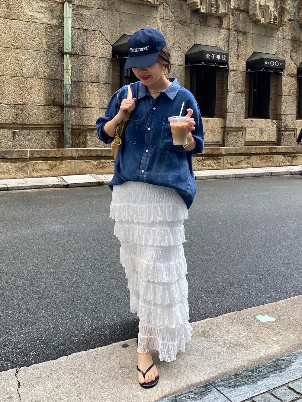 ブルー系のシャツ/ブラウス、ホワイト系のスカート、ゴールド系のネックレスを着用したレディースの春コーディネートの7枚目の写真