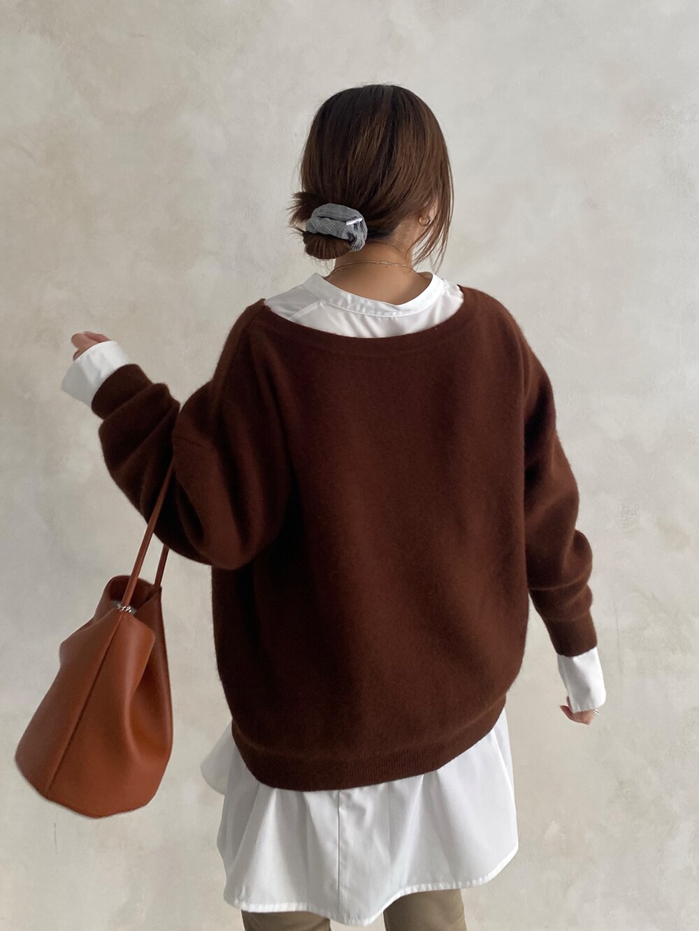 ブラウン系のニット/セーター、ホワイト系のシャツ/ブラウス、ベージュ系のその他パンツを着用したレディースの冬コーディネートの3枚目の写真
