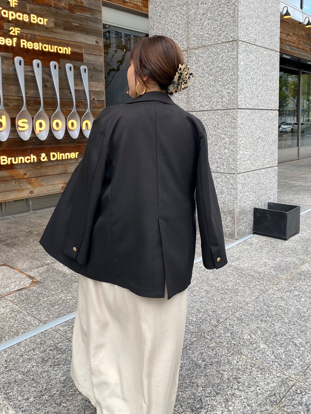 イエロー系のニット/セーター、ベージュ系のワンピース、ブラック系のテーラードジャケットを着用したレディースの冬コーディネートの3枚目の写真