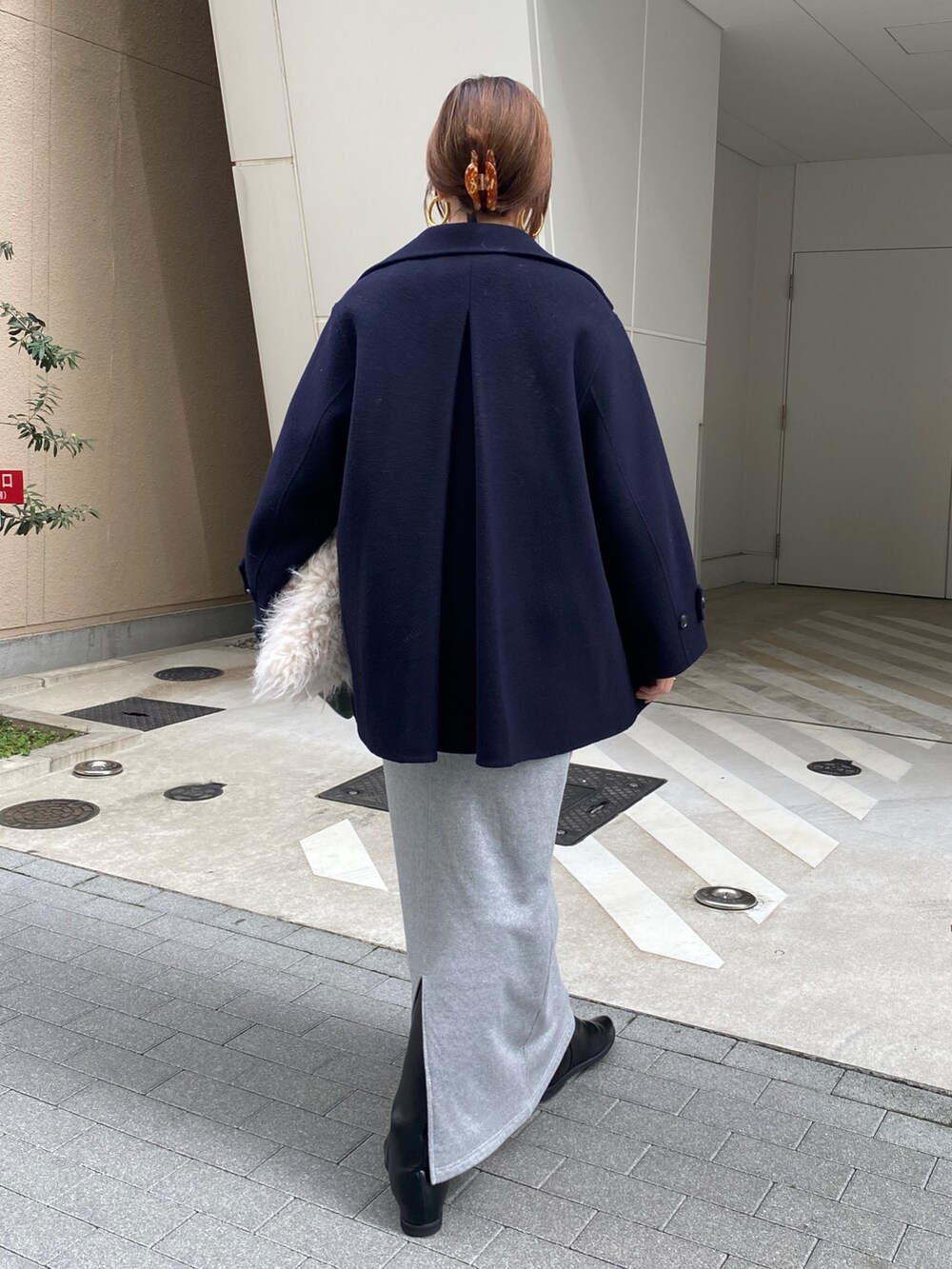 シルバー系のスウェット、シルバー系のスカート、ブラック系のブーツを着用したレディースの秋コーディネートの4枚目の写真