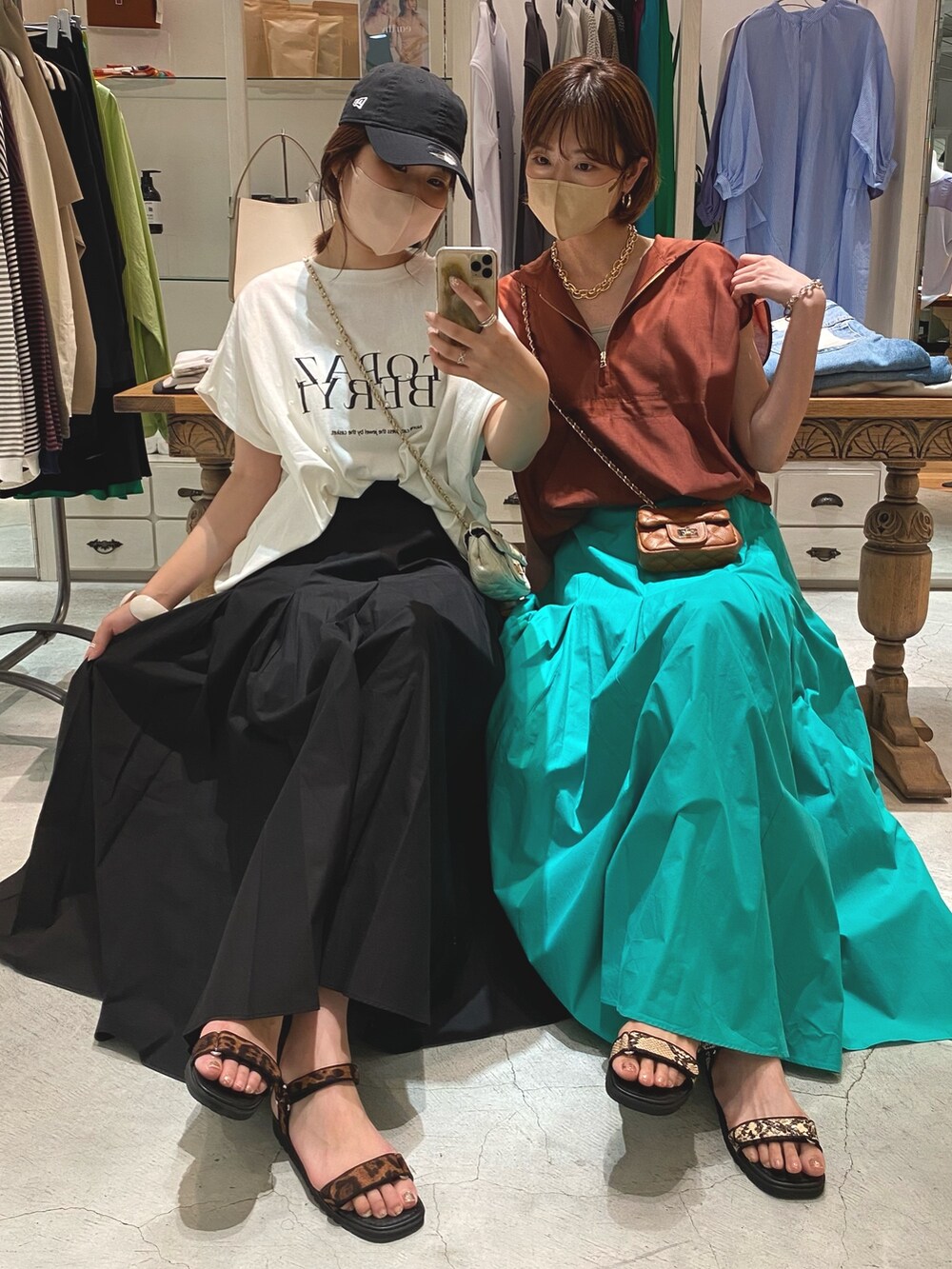 ブルー系のスカート、ホワイト系のTシャツ/カットソー、ブラウン系のシャツ/ブラウスを着用したレディースの夏コーディネートの2枚目の写真