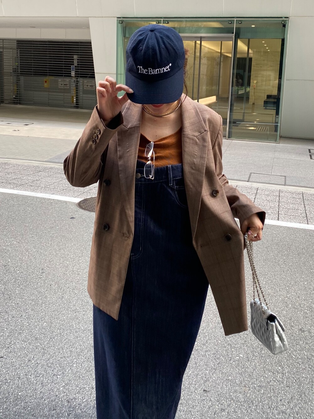 ブルー系のワンピース、シルバー系のショルダーバッグ、ブラウン系のテーラードジャケットを着用したレディースの夏コーディネートの2枚目の写真