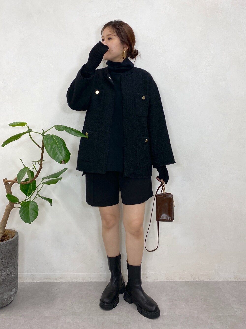 ブラック系のノーカラージャケット、ブラック系のニット/セーター、ブラック系のブーツを着用したレディースの秋コーディネートの2枚目の写真