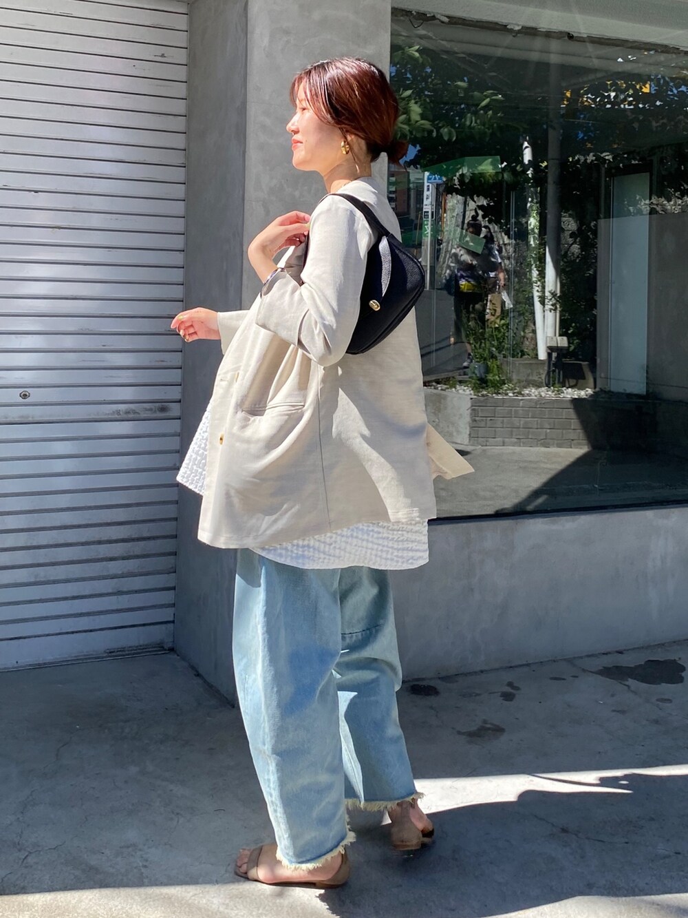 ホワイト系のキャミソール、ブルー系のデニムパンツ、ブラック系のショルダーバッグを着用したレディースの夏コーディネートの10枚目の写真