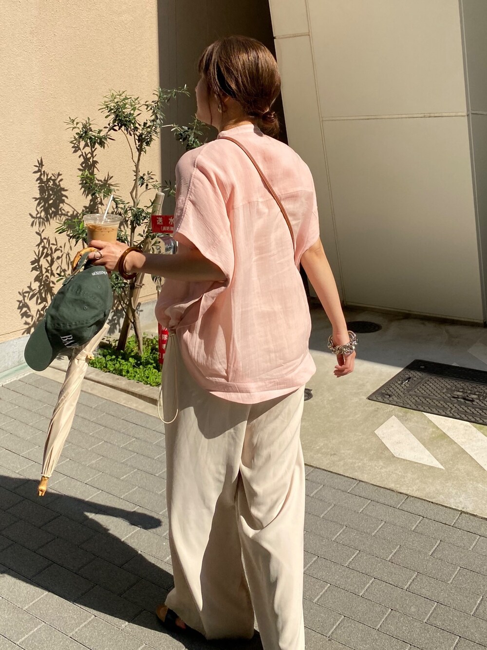 ピンク系のシャツ/ブラウス、ホワイト系のスラックス、ゴールド系のネックレスを着用したレディースの夏コーディネートの6枚目の写真