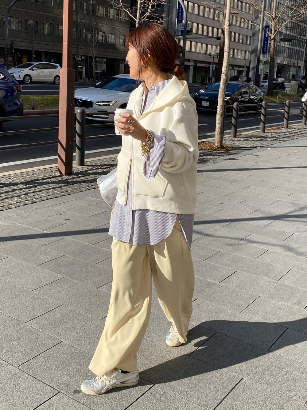 ホワイト系のパーカー、ブラック系のシャツ/ブラウス、イエロー系のスラックスを着用したレディースの冬コーディネートの3枚目の写真