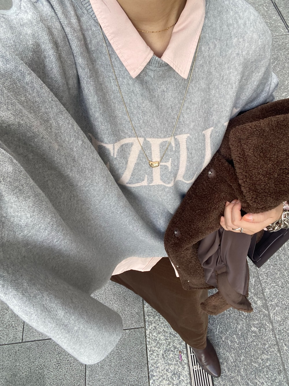 ブラウン系のその他アウター、グレー系のニット/セーター、ピンク系のシャツ/ブラウスを着用したレディースの冬コーディネートの2枚目の写真