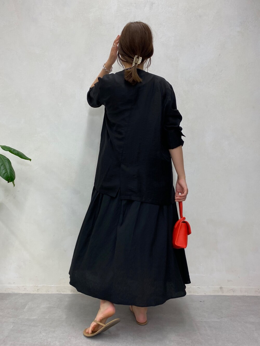 ブラック系のブルゾン、ブラック系のワンピース、ホワイト系のタンクトップを着用したレディースの夏コーディネートの4枚目の写真