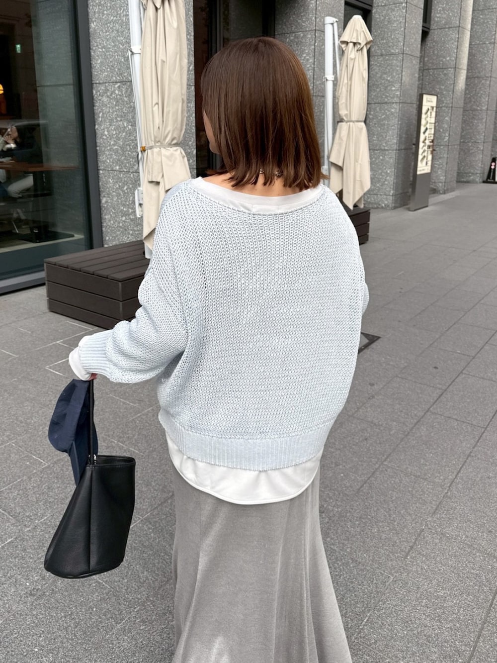 グレー系のTシャツ/カットソー、ブルー系のニット/セーター、グレー系のスカートを着用したレディースの冬コーディネートの3枚目の写真